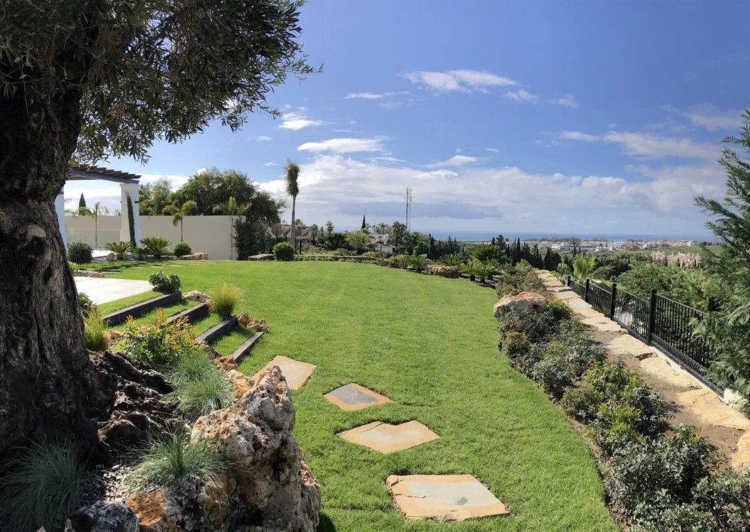 Sendero de piedra natural entre plantación mediterránea en un jardín de Marbella