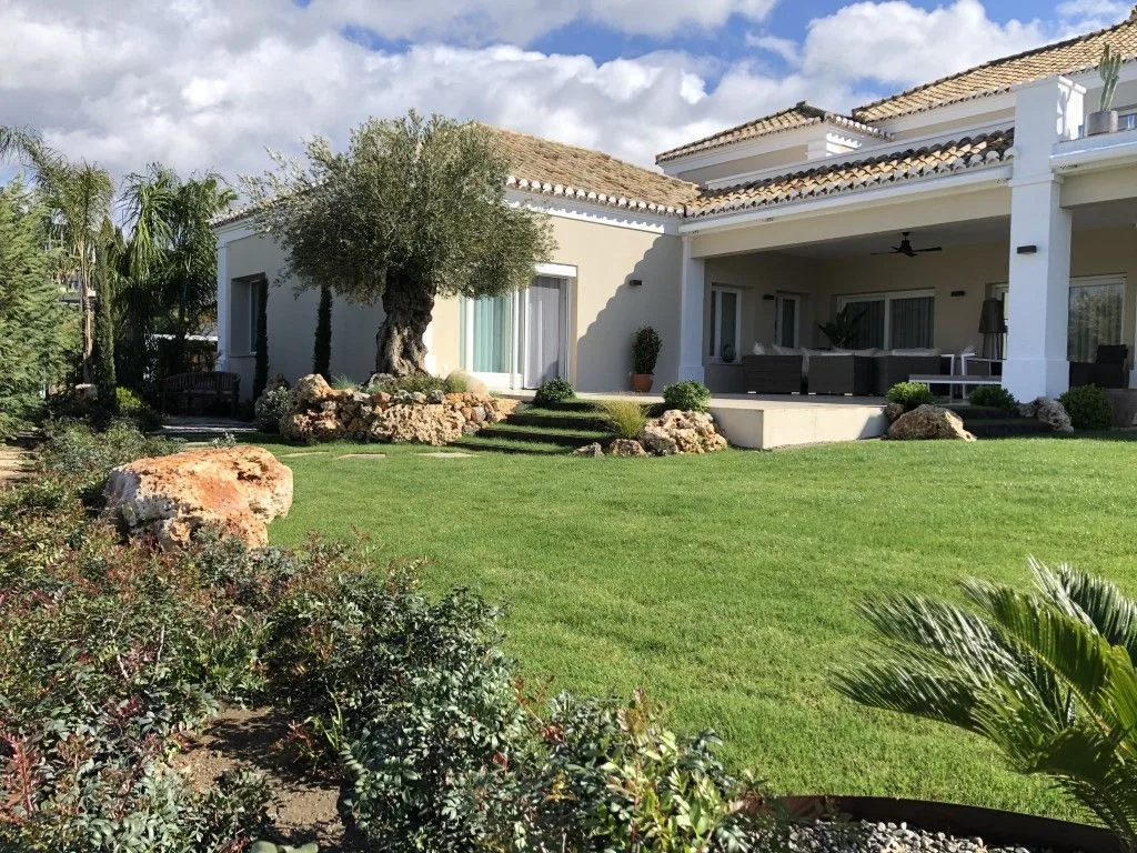 Jardín diseñado en una villa de Marbella con pradera y arbolado